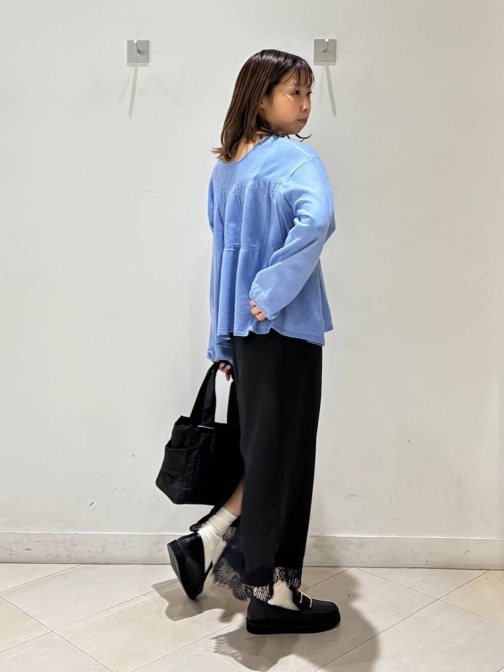 ブラック系のローファー、ブラック系のトートバッグ、ブルー系のカーディガン/ボレロを着用したレディースの春コーディネートの7枚目の写真