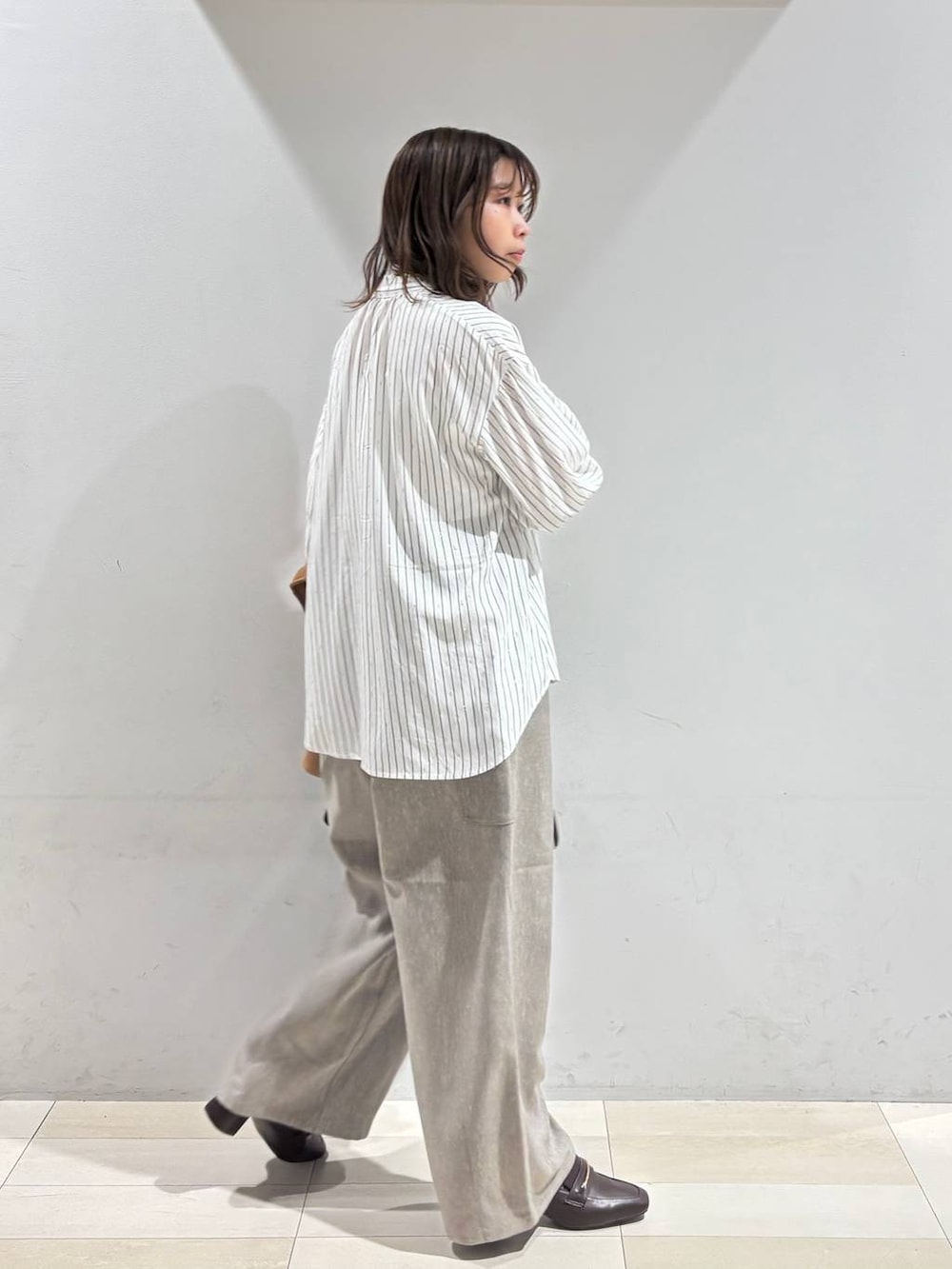 ブラウン系のローファー、ブラウン系のボストンバッグ、ブラウン系のテーラードジャケットを着用したレディースの春コーディネートの7枚目の写真