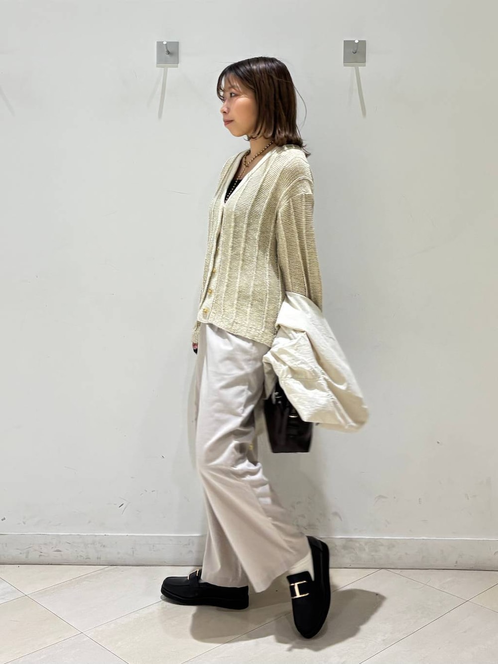 ブラック系のローファー、ブラック系のキャミソール、ブラウン系のボストンバッグを着用したレディースの春コーディネートの4枚目の写真