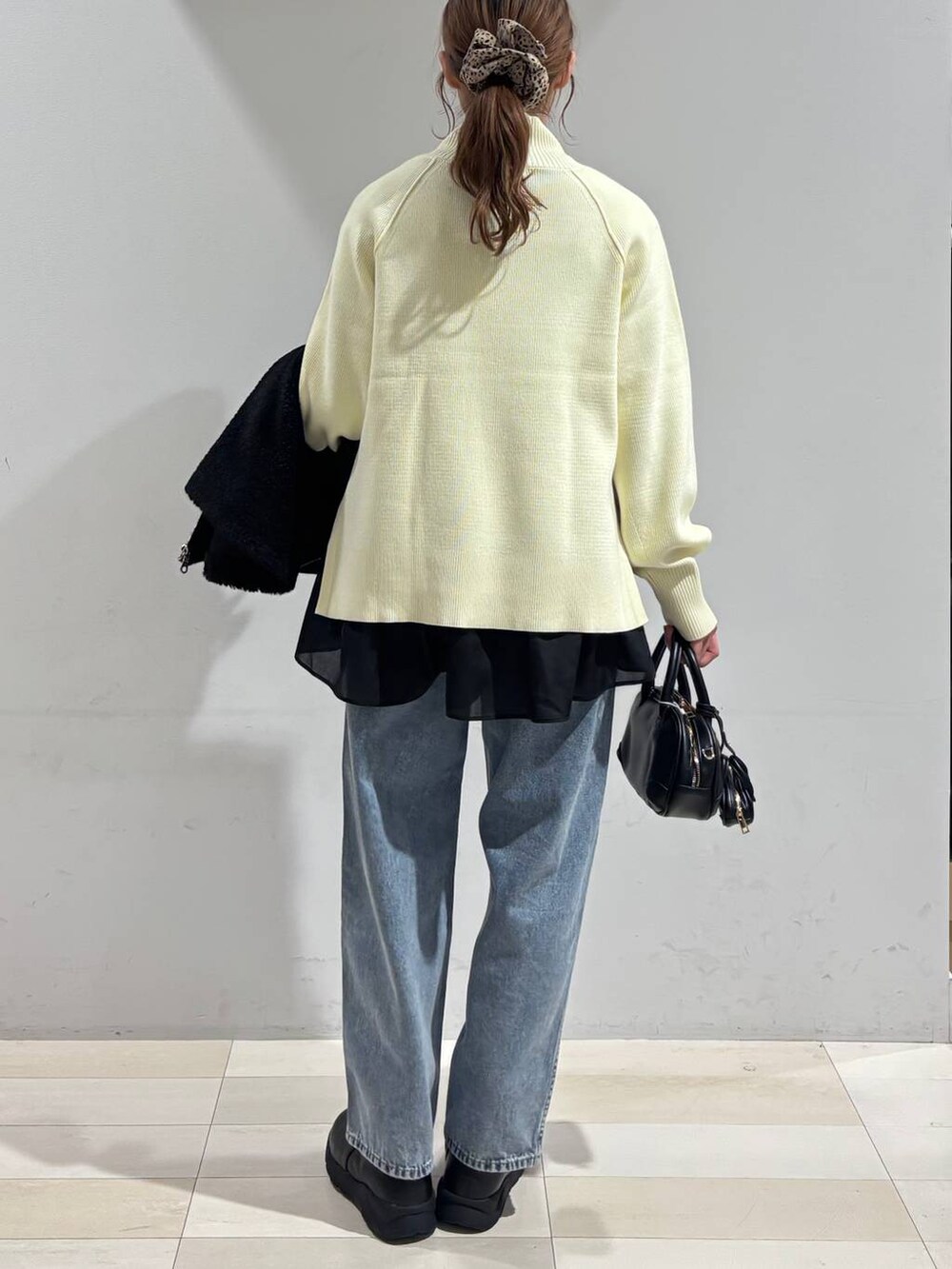 ブルー系のデニムパンツ、ブラック系のブーツ、ブラック系のTシャツ/カットソーを着用したレディースの冬コーディネートの5枚目の写真