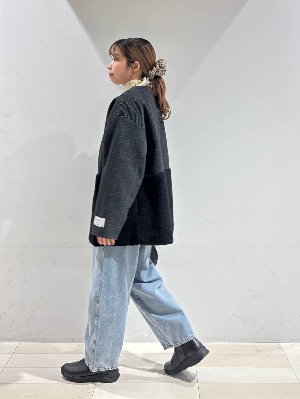 ブルー系のデニムパンツ、ブラック系のブーツ、ブラック系のTシャツ/カットソーを着用したレディースの冬コーディネートの9枚目の写真