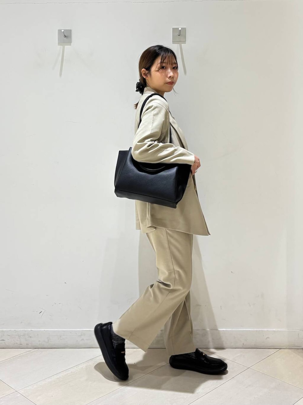 ベージュ系のその他パンツ、ベージュ系のテーラードジャケット、ブラック系のトートバッグを着用したレディースの春コーディネートの8枚目の写真