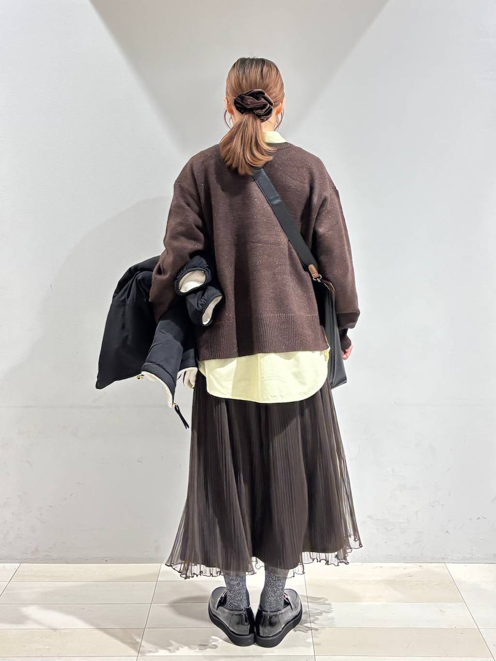 ブラック系のローファー、ブラック系のトートバッグ、ホワイト系のブルゾンを着用したレディースの秋コーディネートの4枚目の写真