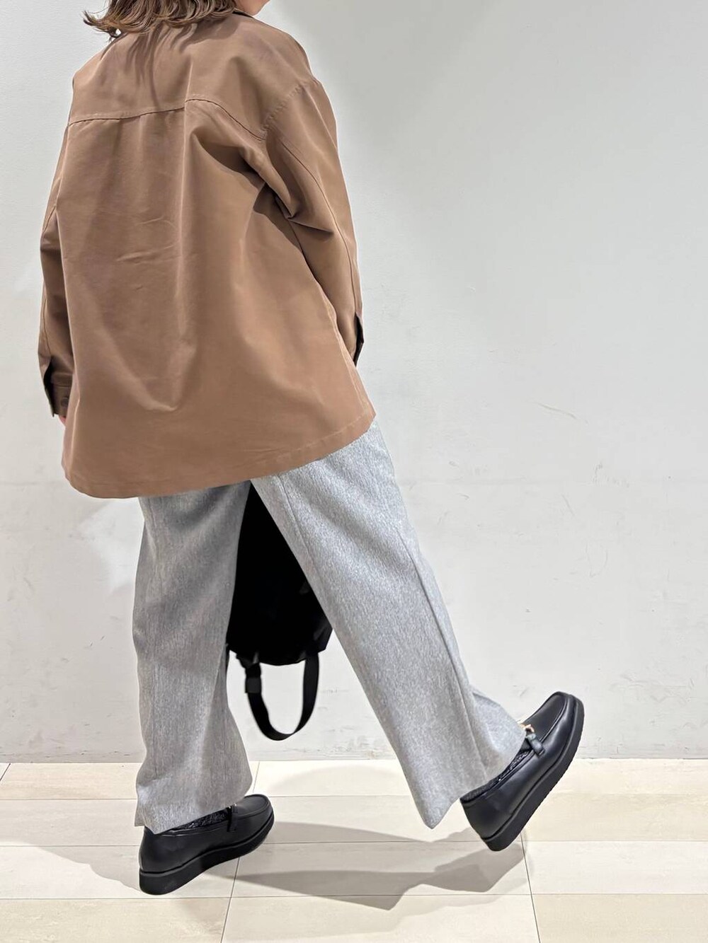 ブラック系のローファー、ブラック系のバックパック/リュック、グレー系のその他パンツを着用したレディースの春コーディネートの6枚目の写真