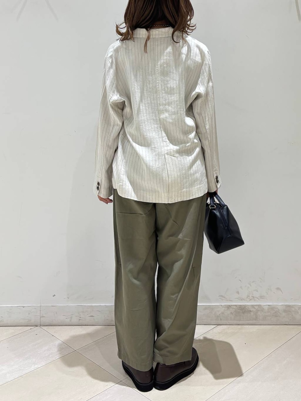 ブラック系のショルダーバッグ、ブラウン系のローファー、ブラック系のキャミソールを着用したレディースの春コーディネートの6枚目の写真