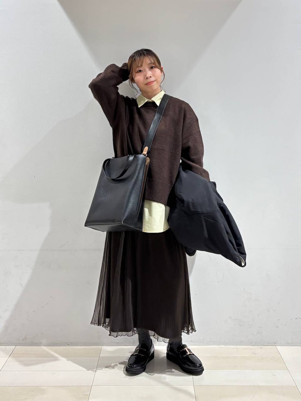 ブラック系のローファー、ブラック系のトートバッグ、ホワイト系のブルゾンを着用したレディースの秋コーディネートの9枚目の写真