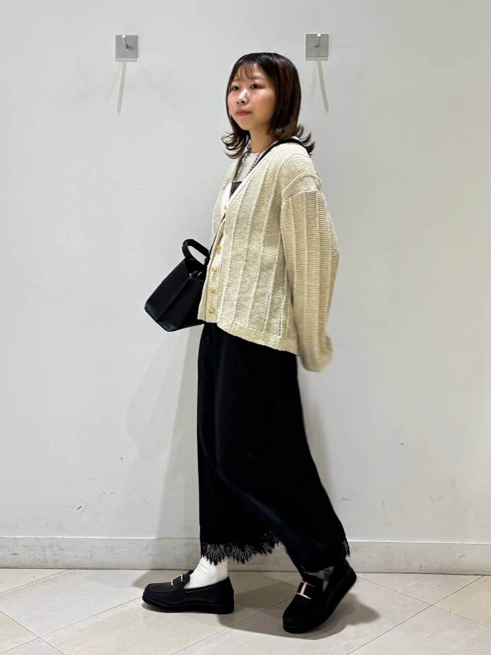 ブラック系のローファー、ホワイト系のTシャツ/カットソー、ホワイト系のカーディガン/ボレロを着用したレディースの春コーディネートの4枚目の写真