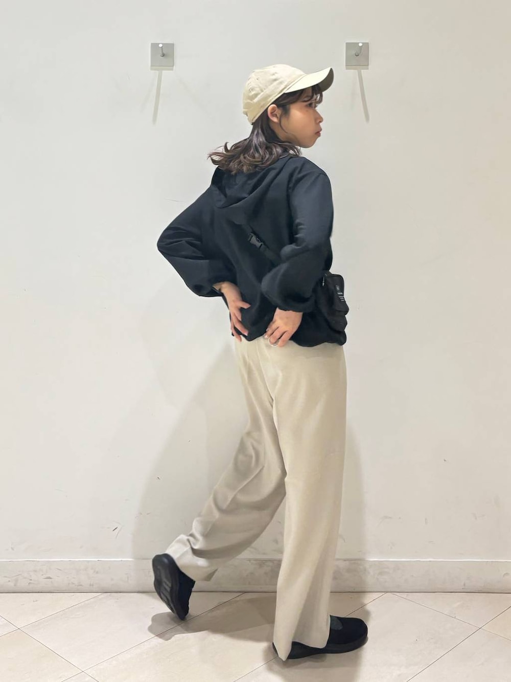 ベージュ系のその他パンツ、ブラック系のマウンテンパーカー、ブラック系のスニーカーを着用したレディースの春コーディネートの6枚目の写真