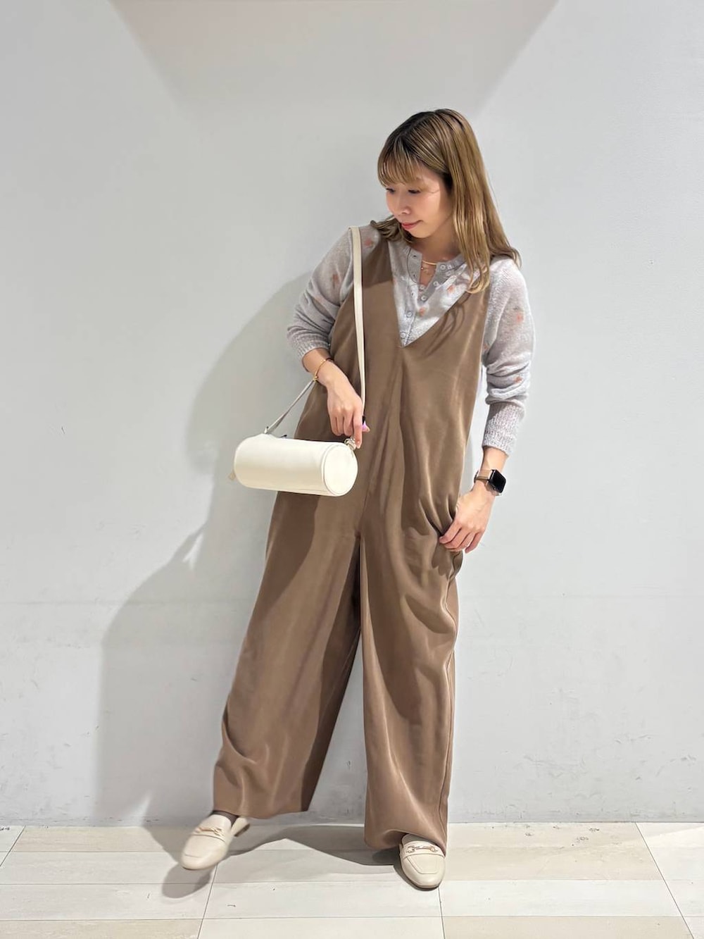 ホワイト系のクラッチバッグ、グレー系のカーディガン/ボレロ、ホワイト系のローファーを着用したレディースの秋コーディネートの8枚目の写真