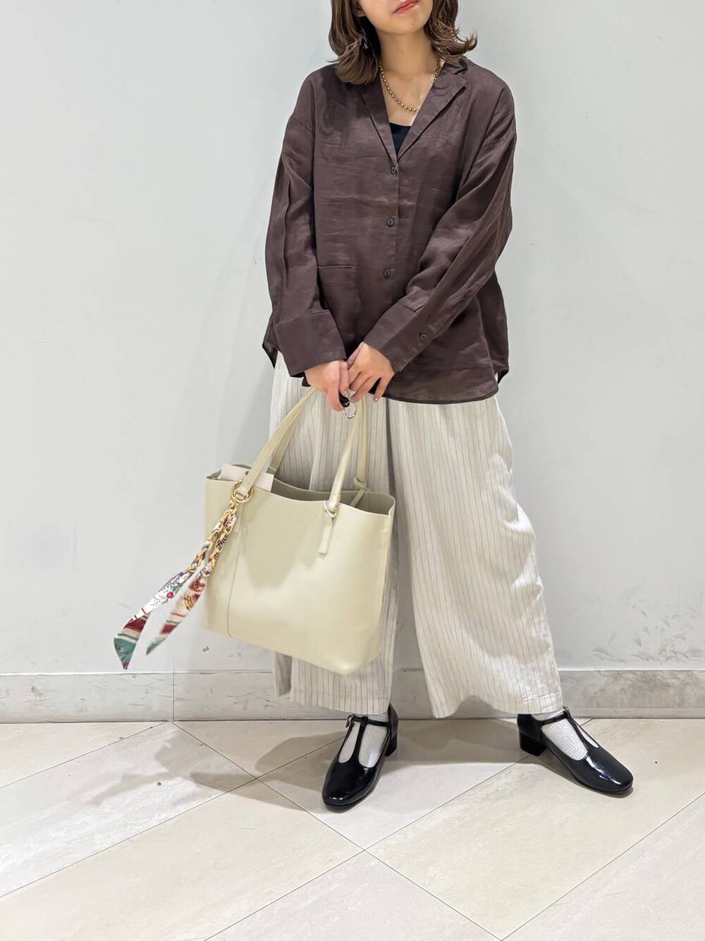 ブラック系のキャミソール、ブラウン系のシャツ/ブラウス、ベージュ系のその他パンツを着用したレディースの春コーディネートの8枚目の写真