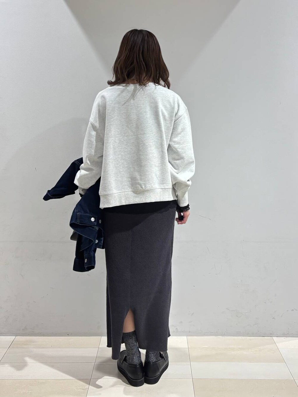 ブラック系のショルダーバッグ、ブラック系のローファー、ブラック系のTシャツ/カットソーを着用したレディースの冬コーディネートの4枚目の写真