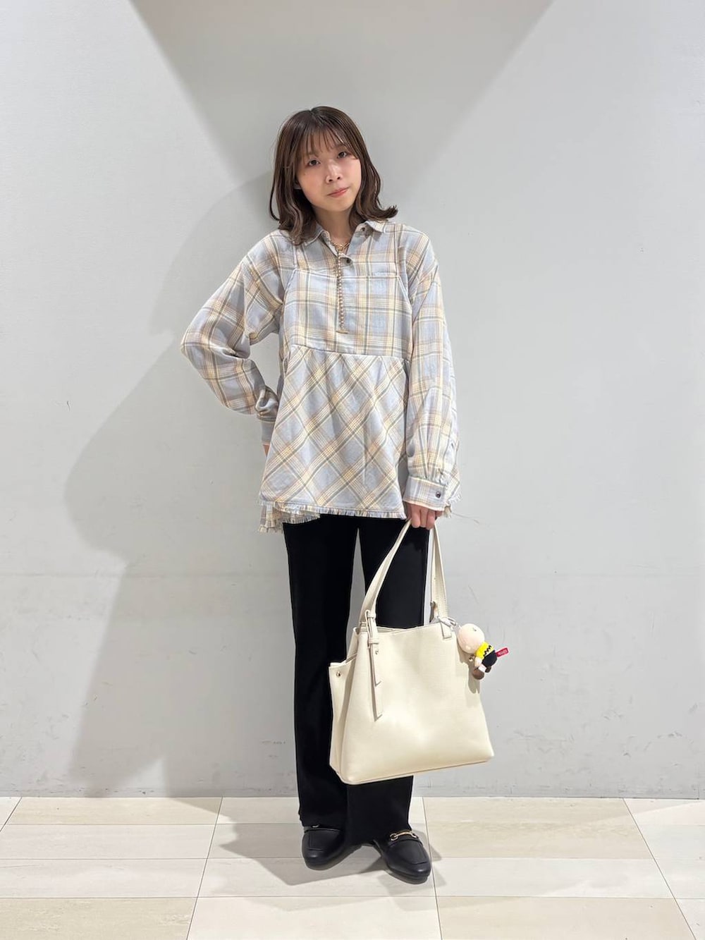 ブラック系のローファー、ホワイト系のハンドバッグ、ブラック系のその他パンツを着用したレディースの冬コーディネートの2枚目の写真