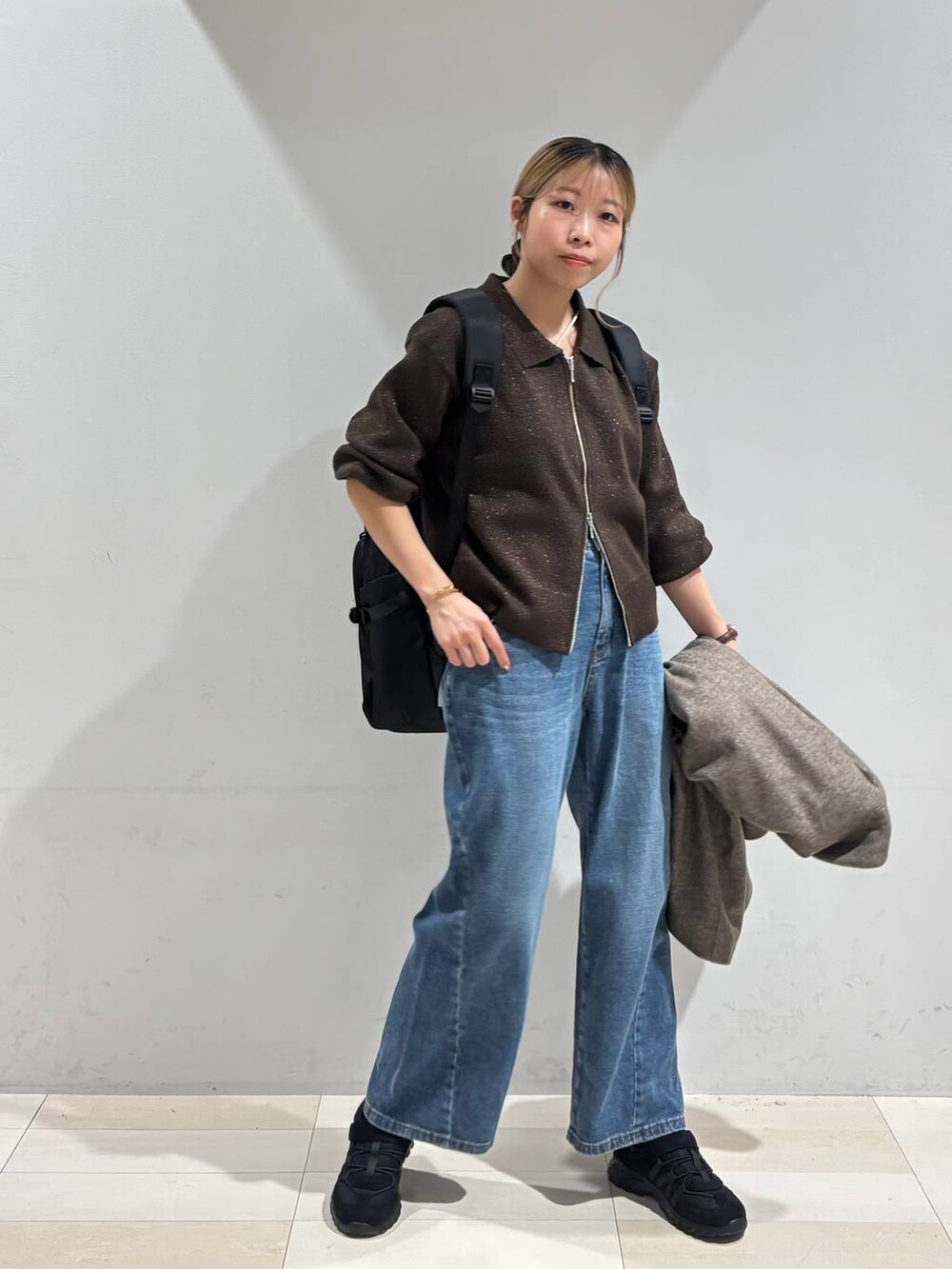 ブラック系のバックパック/リュック、ブラウン系のチェスターコート、ブラウン系のワンピースを着用したレディースの秋コーディネートの6枚目の写真