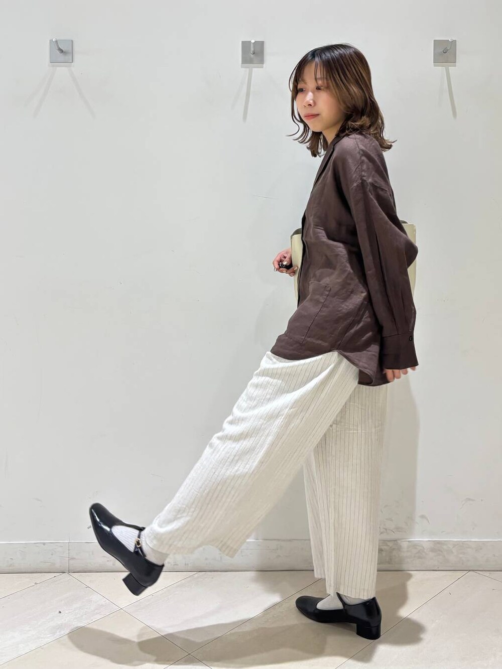 ブラック系のキャミソール、ブラウン系のシャツ/ブラウス、ベージュ系のその他パンツを着用したレディースの春コーディネートの6枚目の写真