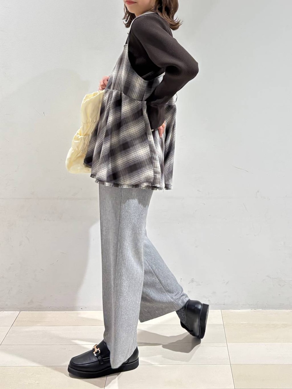 ブラック系のローファー、ベージュ系のトートバッグ、グレー系のその他パンツを着用したレディースの春コーディネートの7枚目の写真