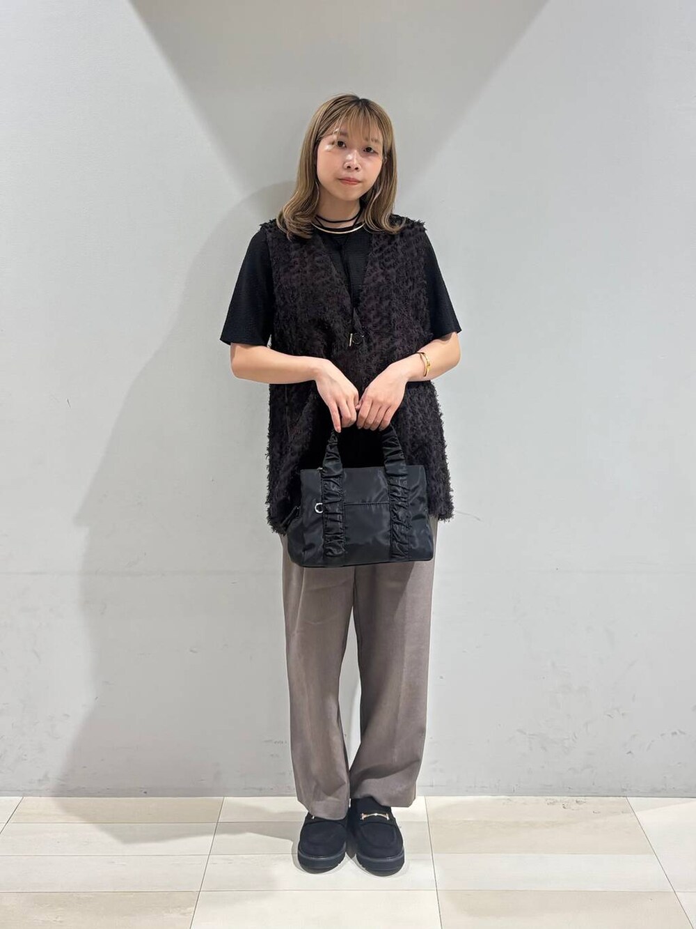 ブラック系のショルダーバッグ、ブラック系のTシャツ/カットソー、ブラック系のローファーを着用したレディースの秋コーディネートの9枚目の写真