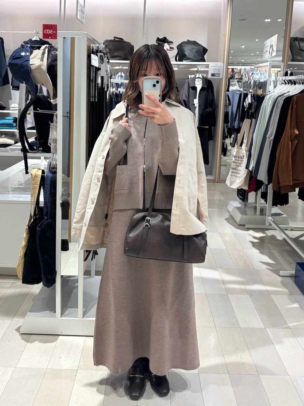 ブラウン系のローファー、ホワイト系のデニムジャケット、ブラウン系のショルダーバッグを着用したレディースの春コーディネートの2枚目の写真