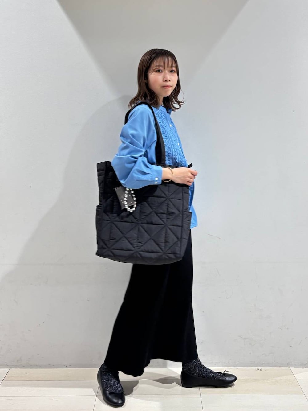 ブラック系のバレエシューズ、ブラック系のトートバッグ、ブラック系のスカートを着用したレディースの冬コーディネートの4枚目の写真