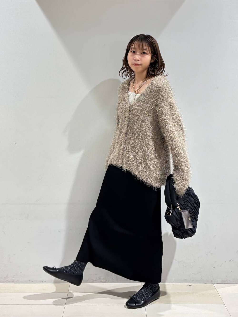 ブラック系のバレエシューズ、ブラック系のトートバッグ、ブラック系のスカートを着用したレディースの春コーディネートの2枚目の写真