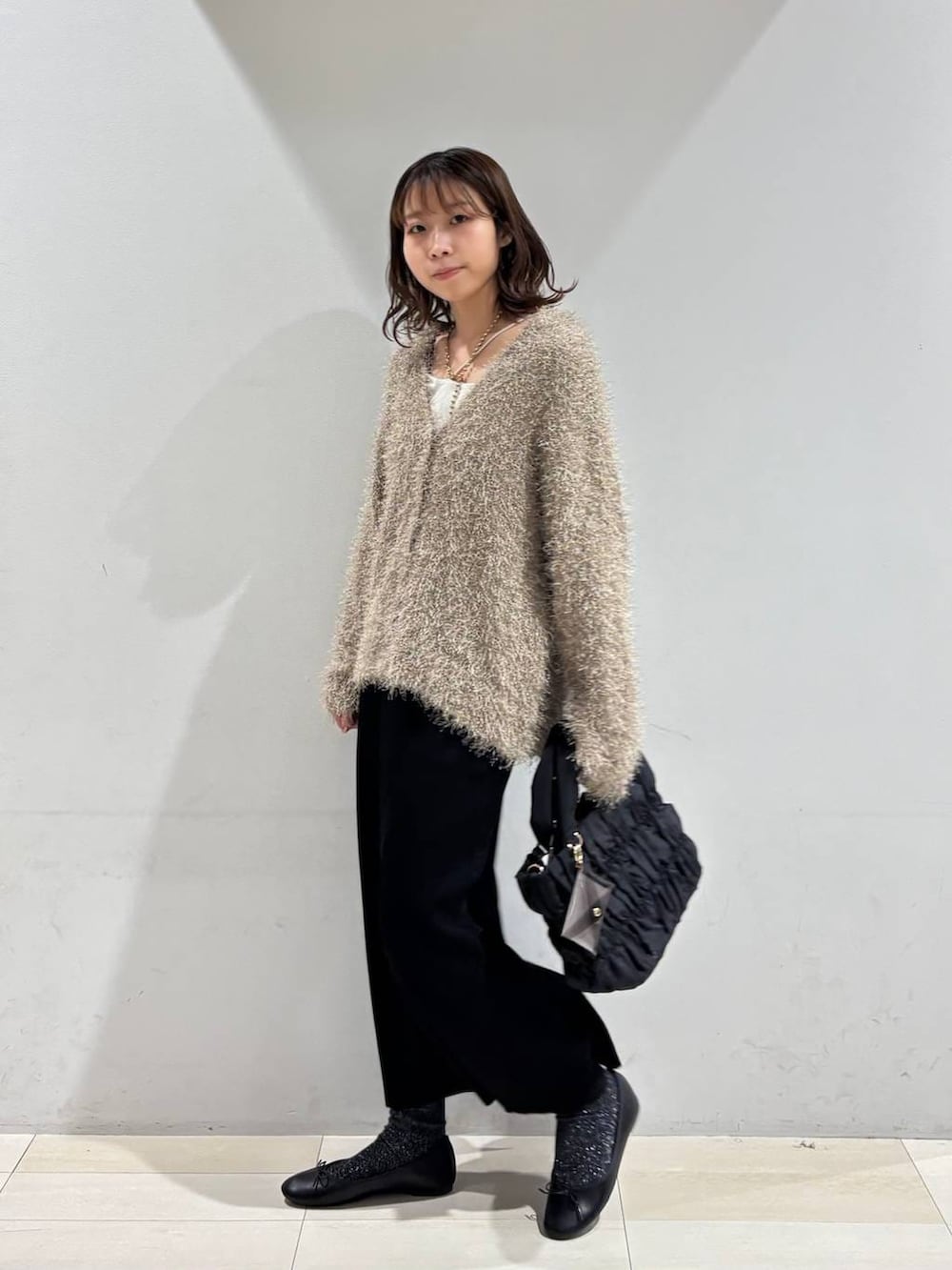 ブラック系のバレエシューズ、ブラック系のトートバッグ、ブラック系のスカートを着用したレディースの春コーディネートの3枚目の写真