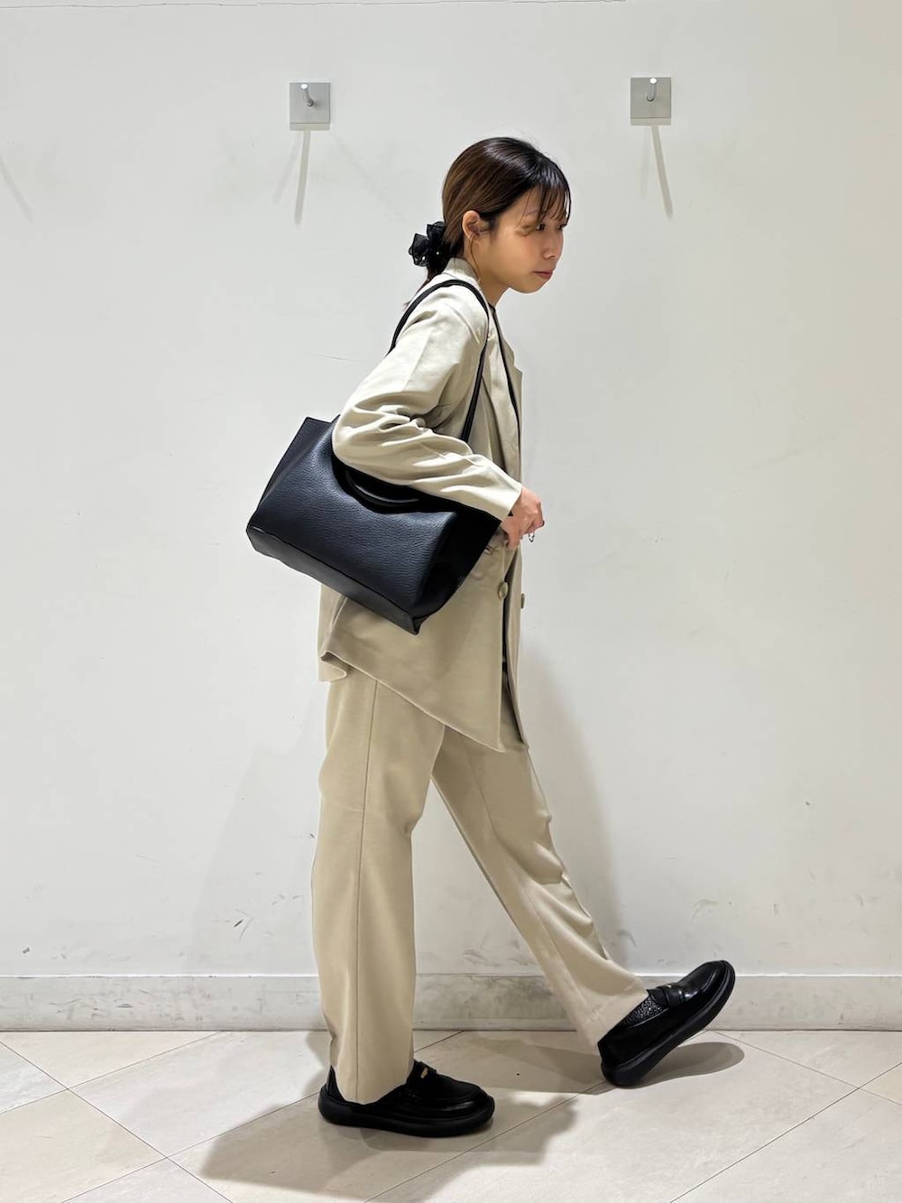 ベージュ系のその他パンツ、ベージュ系のテーラードジャケット、ブラック系のトートバッグを着用したレディースの春コーディネートの9枚目の写真