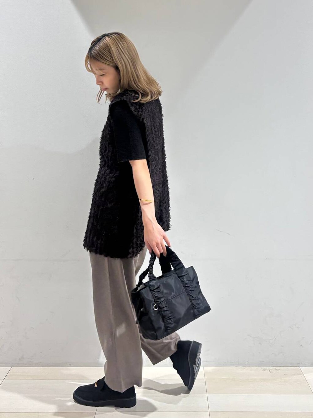 ブラック系のショルダーバッグ、ブラック系のTシャツ/カットソー、ブラック系のローファーを着用したレディースの秋コーディネートの6枚目の写真