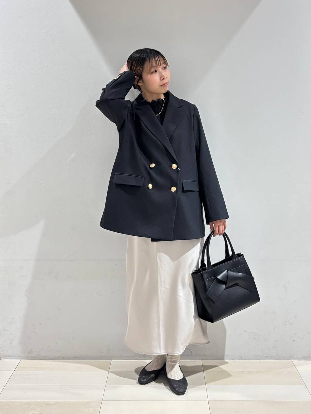 ブラック系のパンプス、ブラック系のシャツ/ブラウス、ブラック系のハンドバッグを着用したレディースの冬コーディネートの9枚目の写真