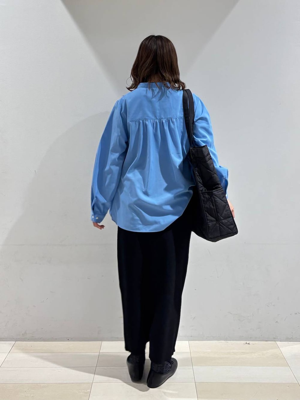 ブラック系のバレエシューズ、ブラック系のトートバッグ、ブラック系のスカートを着用したレディースの冬コーディネートの5枚目の写真