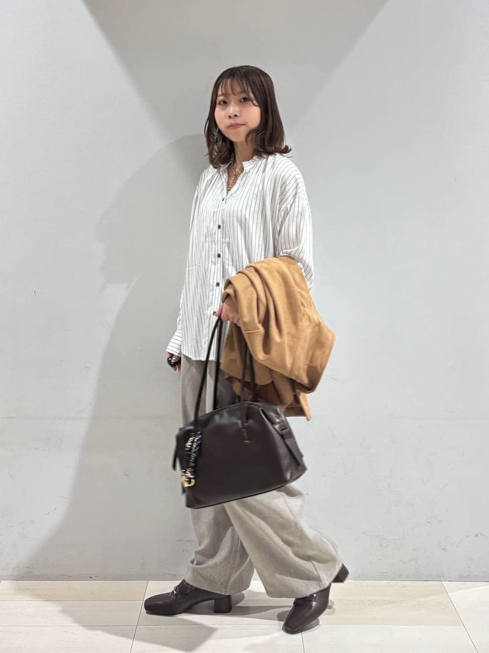 ブラウン系のローファー、ブラウン系のボストンバッグ、ブラウン系のテーラードジャケットを着用したレディースの春コーディネートの4枚目の写真