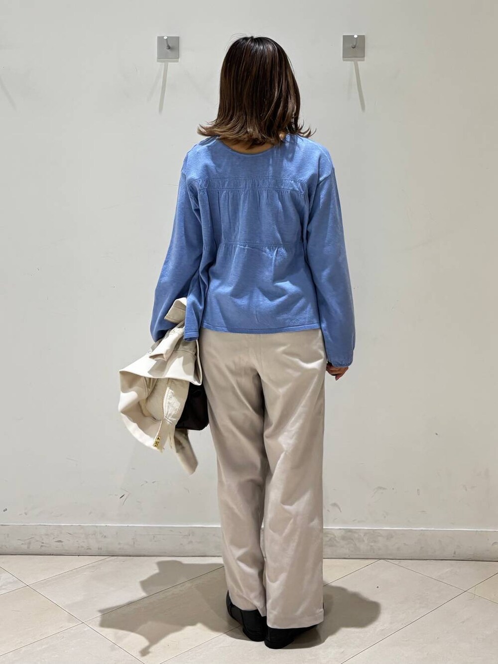 ブラック系のローファー、ホワイト系のその他パンツ、ブラウン系のボストンバッグを着用したレディースの春コーディネートの5枚目の写真