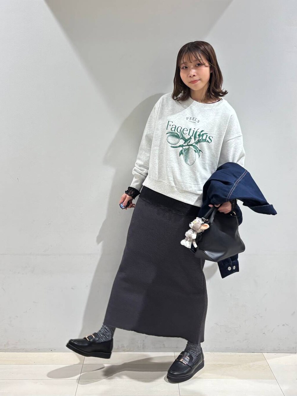ブラック系のショルダーバッグ、ブラック系のローファー、ブラック系のTシャツ/カットソーを着用したレディースの冬コーディネートの2枚目の写真