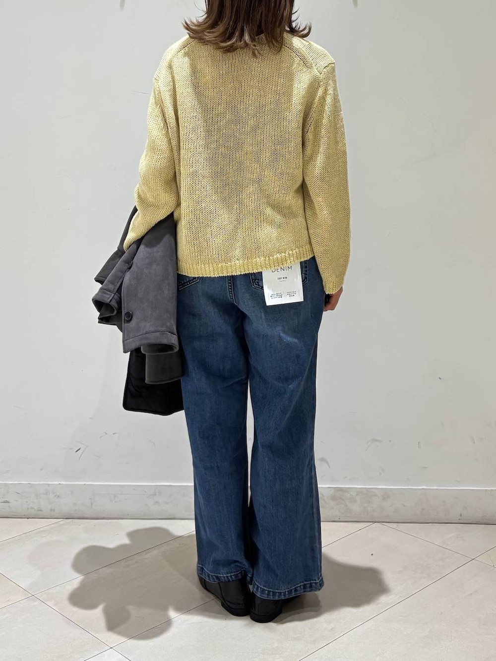 ブラック系のローファー、ブラック系のトートバッグ、ブルー系のデニムパンツを着用したレディースの春コーディネートの4枚目の写真