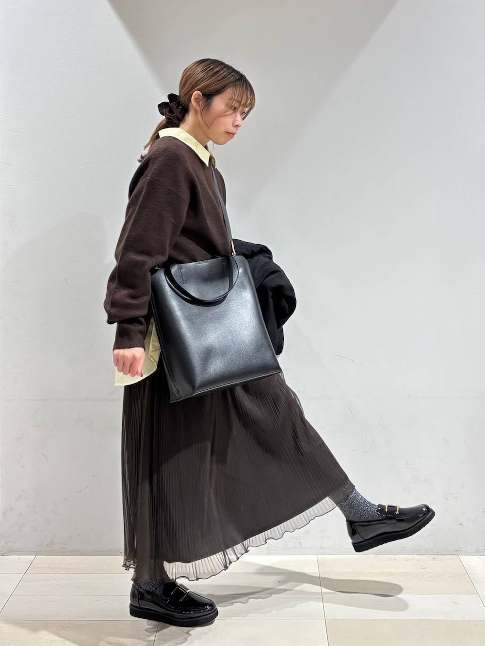 ブラック系のローファー、ブラック系のトートバッグ、ホワイト系のブルゾンを着用したレディースの秋コーディネートの3枚目の写真