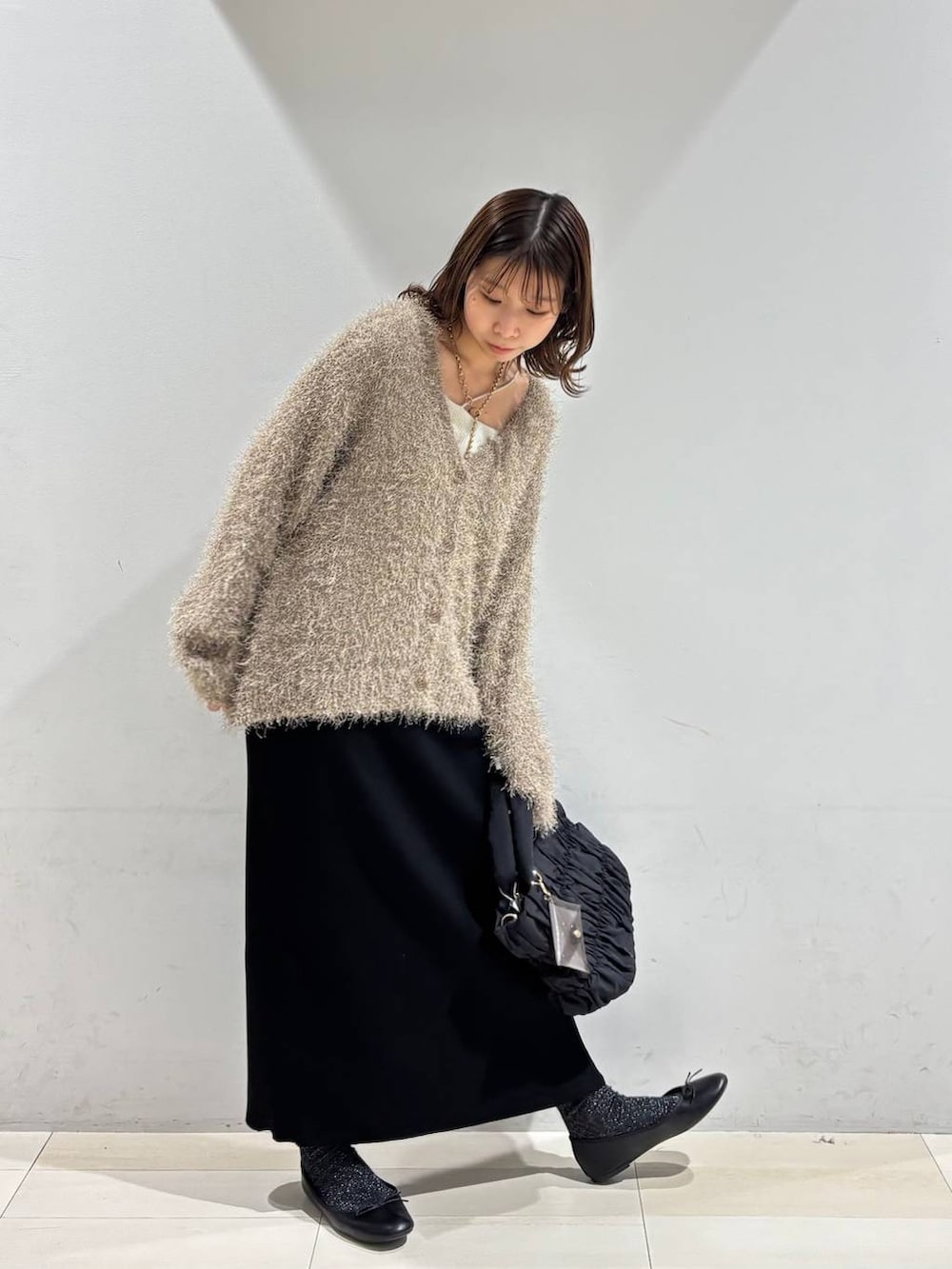 ブラック系のバレエシューズ、ブラック系のトートバッグ、ブラック系のスカートを着用したレディースの春コーディネートの9枚目の写真