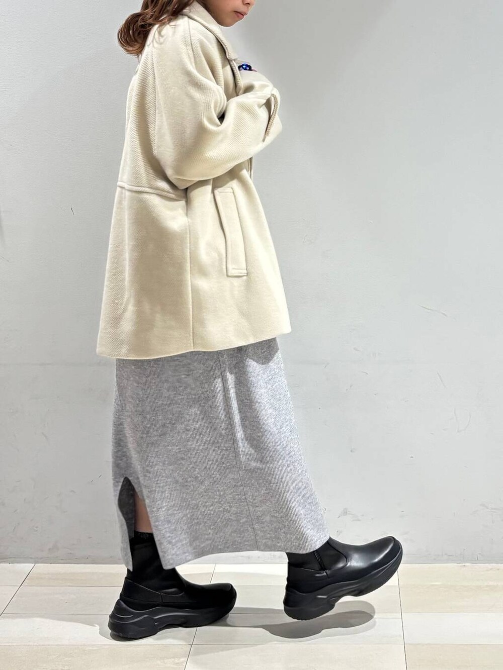 ブラック系のショルダーバッグ、グレー系のワンピース、ブラック系のブーツを着用したレディースの冬コーディネートの5枚目の写真