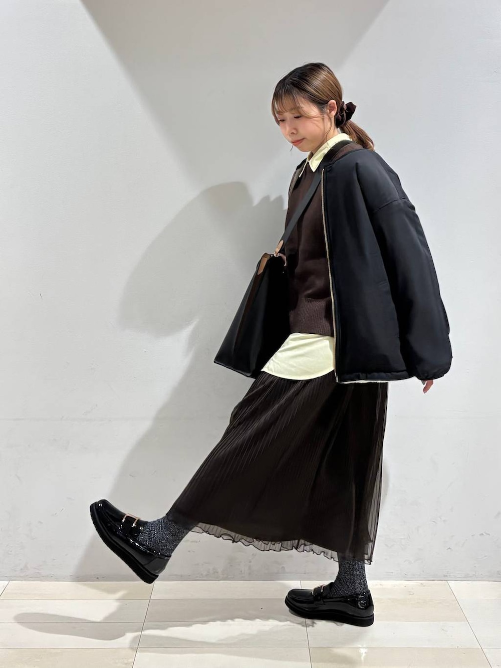 ブラック系のローファー、ブラック系のトートバッグ、ホワイト系のブルゾンを着用したレディースの秋コーディネートの7枚目の写真