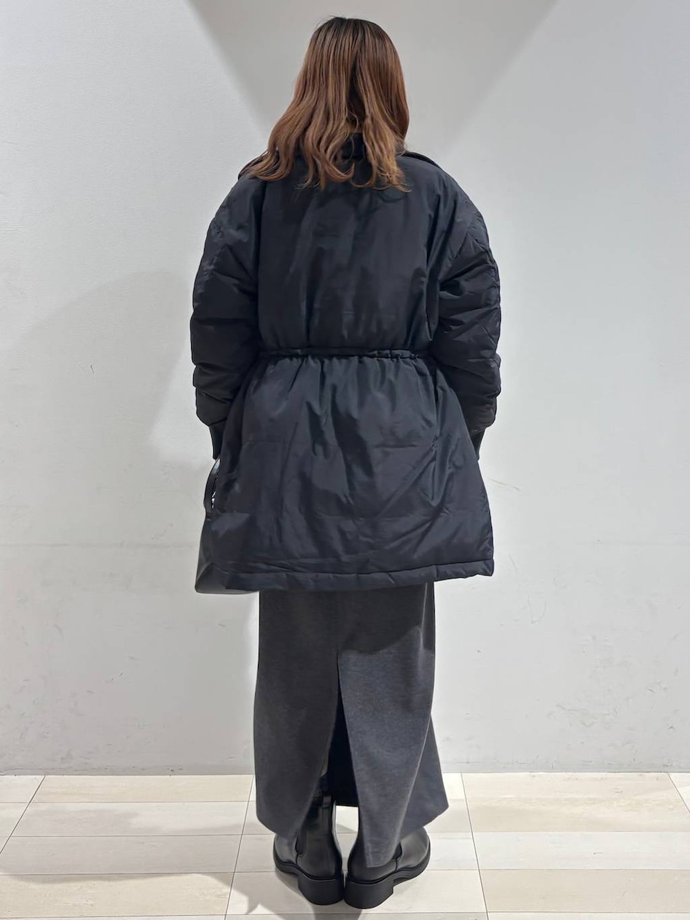 ブラック系のショルダーバッグ、ブラック系のダウンジャケット/コート、ホワイト系のTシャツ/カットソーを着用したレディースの冬コーディネートの6枚目の写真