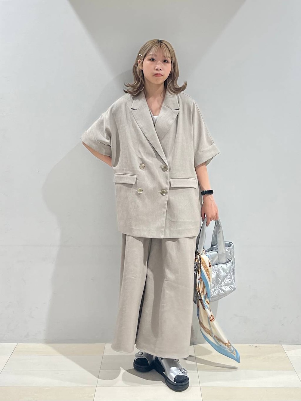 シルバー系のトートバッグ、ホワイト系のキャミソール、シルバー系のサンダルを着用したレディースの夏コーディネートの9枚目の写真