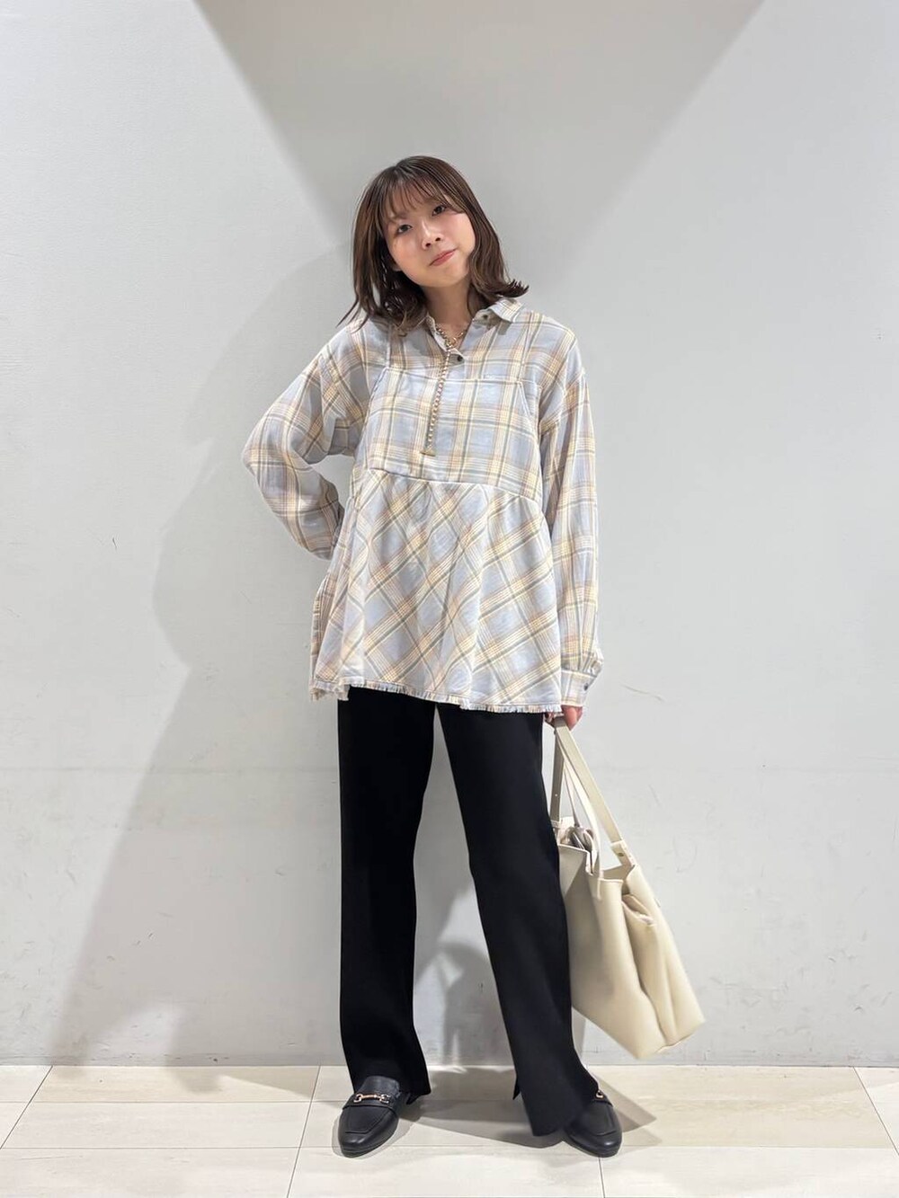 ブラック系のローファー、ホワイト系のハンドバッグ、ブラック系のその他パンツを着用したレディースの冬コーディネートの8枚目の写真