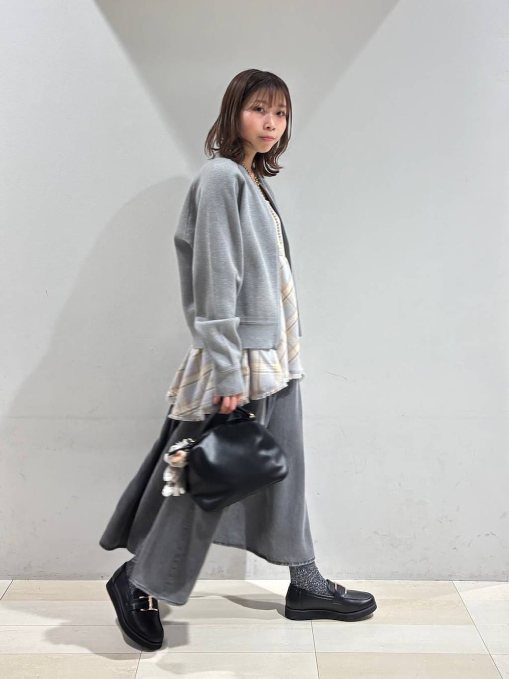 ブラック系のショルダーバッグ、ブラック系のローファー、ブルー系のその他トップスを着用したレディースの春コーディネートの3枚目の写真