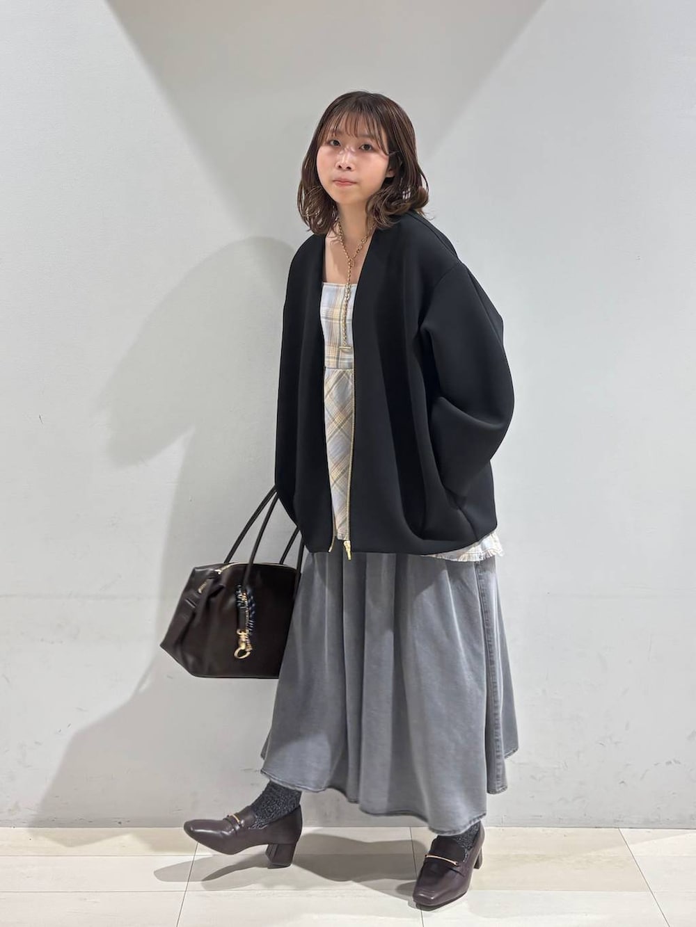 ブラウン系のローファー、ブラウン系のボストンバッグ、ブラック系のブルゾンを着用したレディースの春コーディネートの9枚目の写真