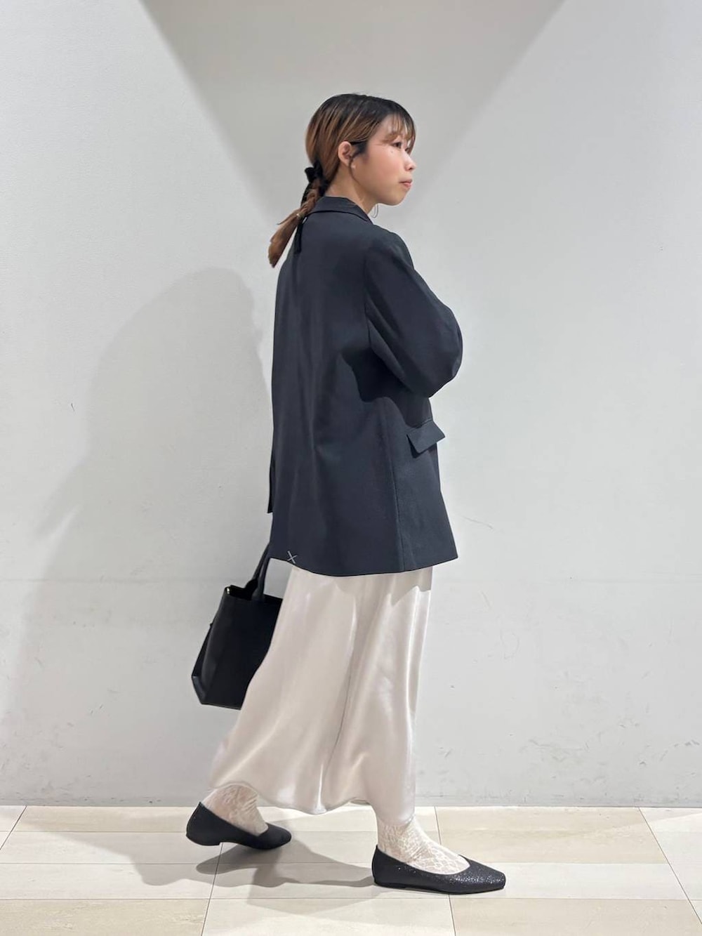 ブラック系のパンプス、ブラック系のシャツ/ブラウス、ブラック系のハンドバッグを着用したレディースの冬コーディネートの7枚目の写真