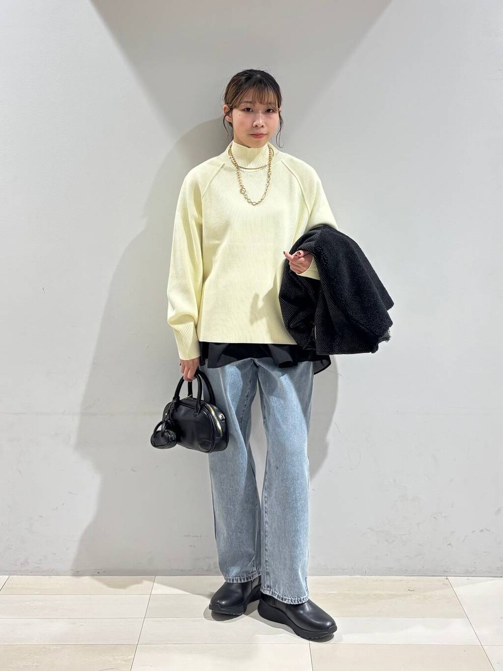 ブルー系のデニムパンツ、ブラック系のブーツ、ブラック系のTシャツ/カットソーを着用したレディースの冬コーディネートの2枚目の写真