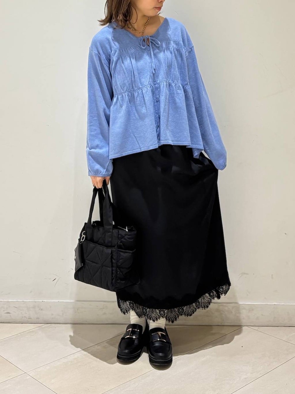 ブラック系のローファー、ブラック系のトートバッグ、ブルー系のカーディガン/ボレロを着用したレディースの春コーディネートの2枚目の写真