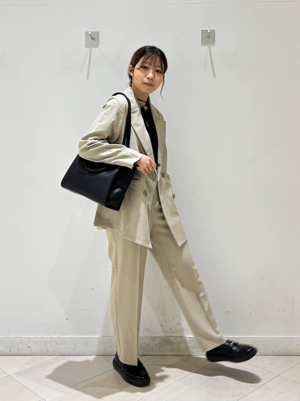 ベージュ系のその他パンツ、ベージュ系のテーラードジャケット、ブラック系のトートバッグを着用したレディースの春コーディネートの7枚目の写真