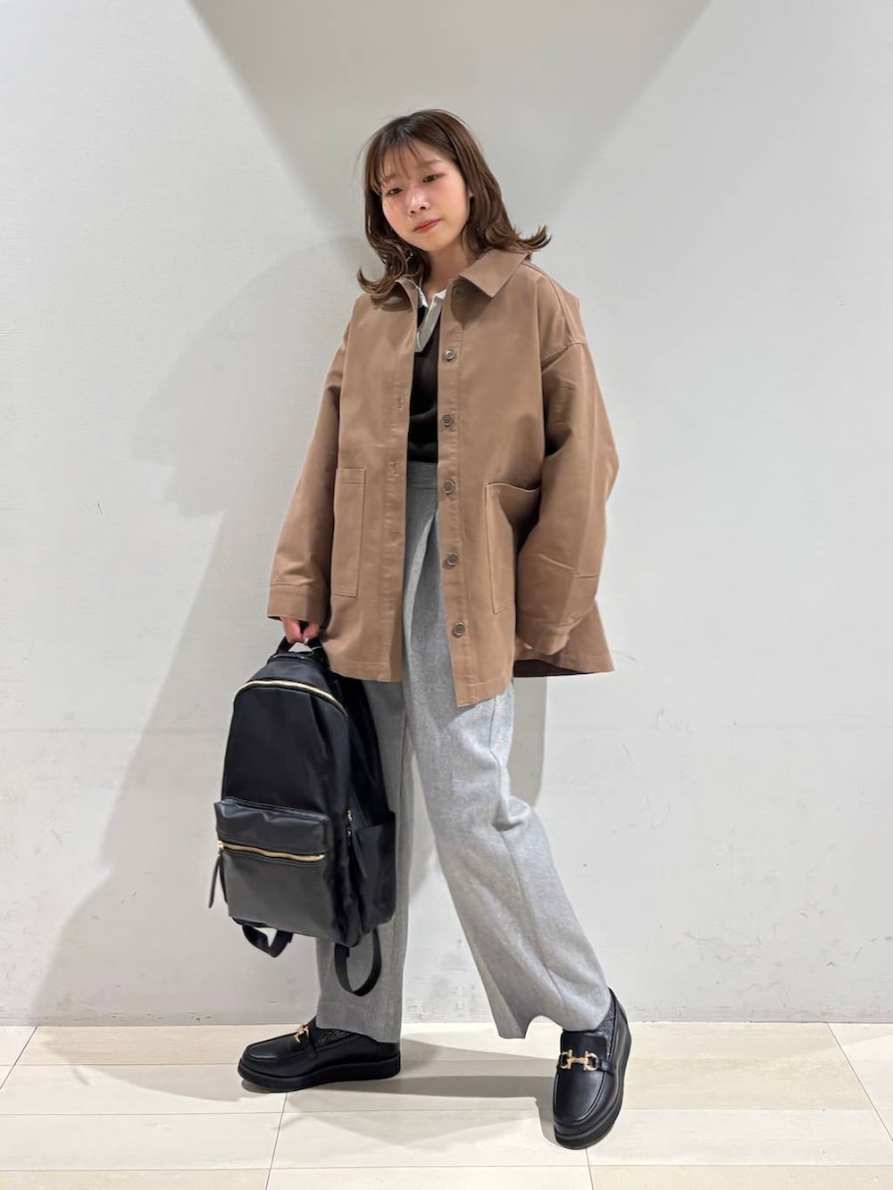 ブラック系のローファー、ブラック系のバックパック/リュック、グレー系のその他パンツを着用したレディースの春コーディネートの4枚目の写真