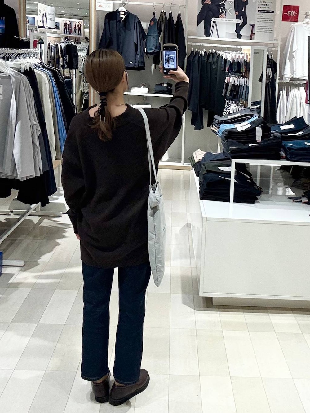 ブラウン系のローファー、ブルー系のデニムパンツ、ブラウン系のカーディガン/ボレロを着用したレディースの秋コーディネートの3枚目の写真