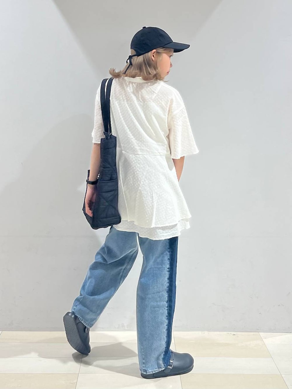 ブラック系のトートバッグ、ホワイト系のキャミソール、ブラック系のサンダルを着用したレディースの夏コーディネートの5枚目の写真