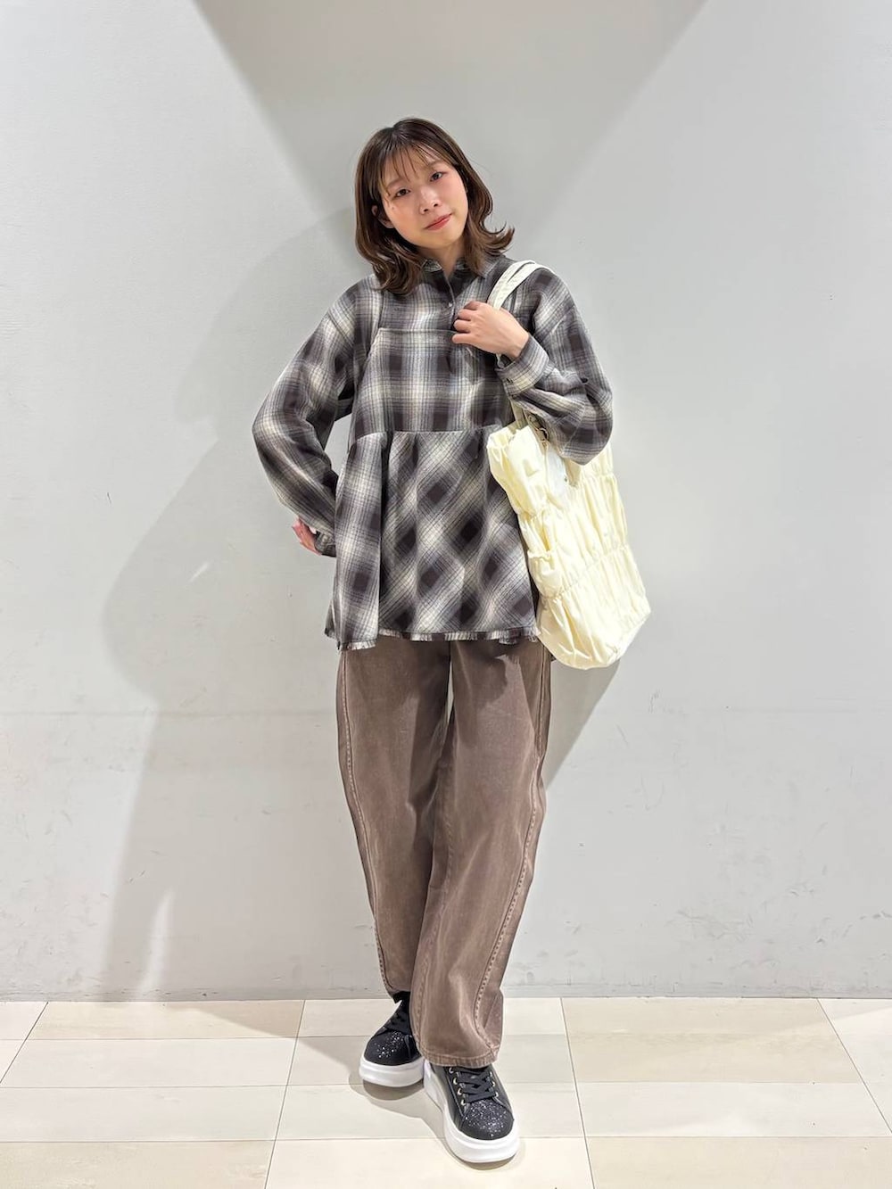 ベージュ系のトートバッグ、ブラウン系のデニムパンツ、ブラウン系のシャツ/ブラウスを着用したレディースの春コーディネートの9枚目の写真