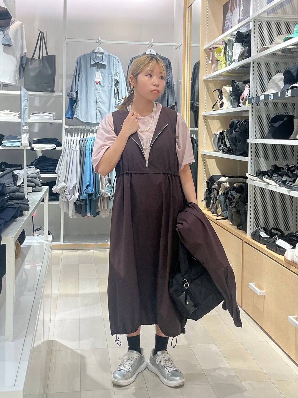 シルバー系のスニーカー、ブラック系のトートバッグ、ピンク系のTシャツ/カットソーを着用したレディースの夏コーディネートの5枚目の写真